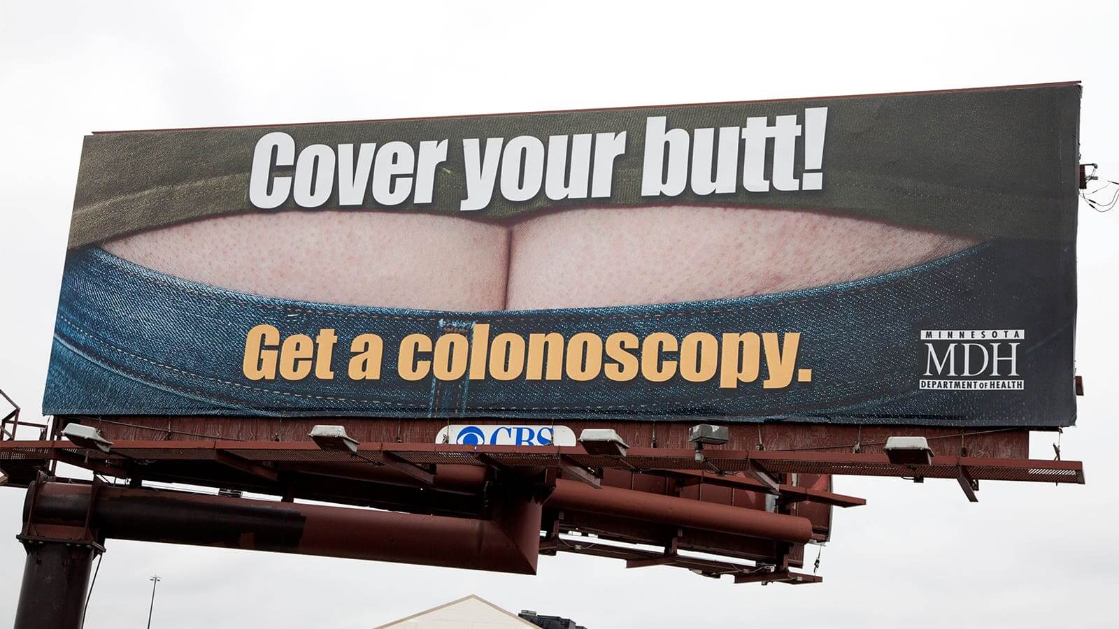 A photo of a billboard which reads: Cover your butt! Get a colonoscopy today.