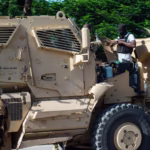 Kenyan police officers are seen leaving an armored vehicle Credit: AFP