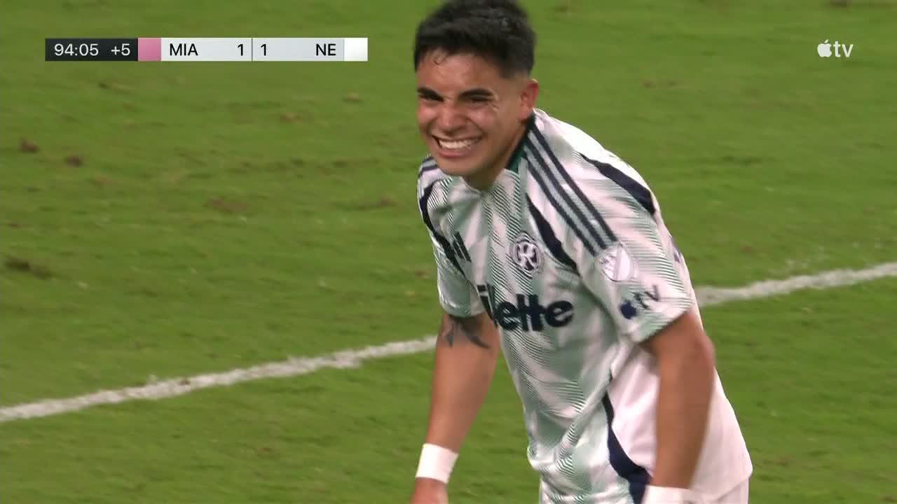 Soccer player in a white jersey grins while on a green field during a 1-1 Miami–New England match, shown at 94:05 with extra time on screen.