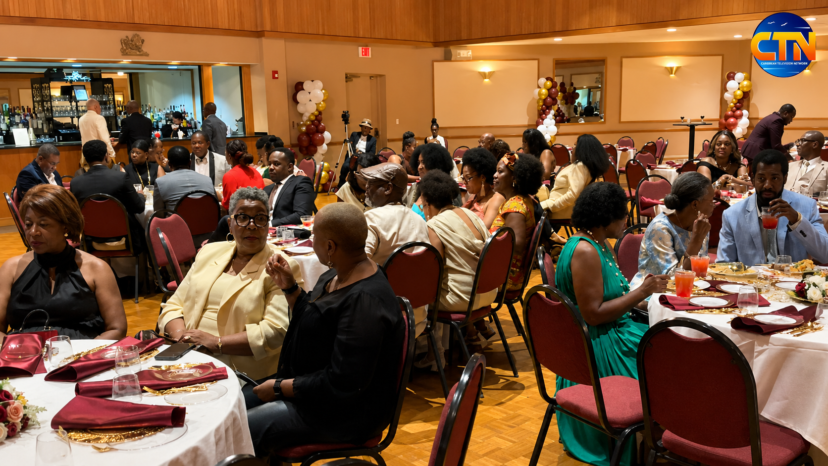 ChatGPT Image Jul 26 2026 03_25_23 AM 2 - Caribbean Television Network Guests seated at round tables in a decorated banquet hall, enjoying food and drinks at a formal event with a bar in the background.