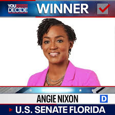 Portrait of a smiling woman in a pink blazer on a political broadcast banner labeled 'WINNER' for U.S. Senate Florida.